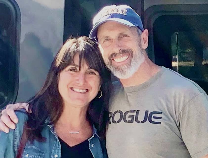 Steve and Marla arm in arm next to their van.