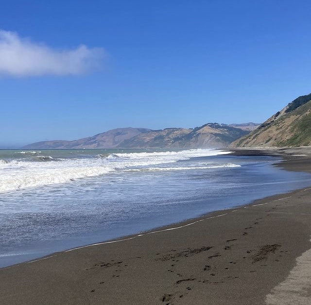 looking north up the beach from mattole campground showing the ocean and hills to the right and in the distance.