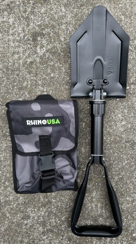 Unfolded Rhino USA shovel next to its carrying bag.