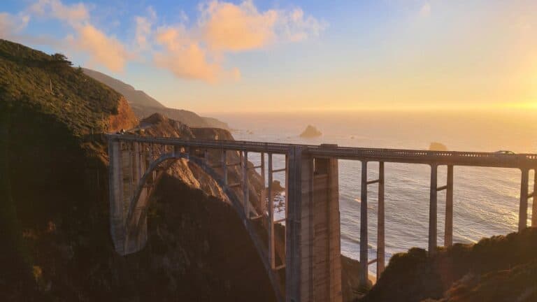 the orange shade of the sunset through the big sur bridge