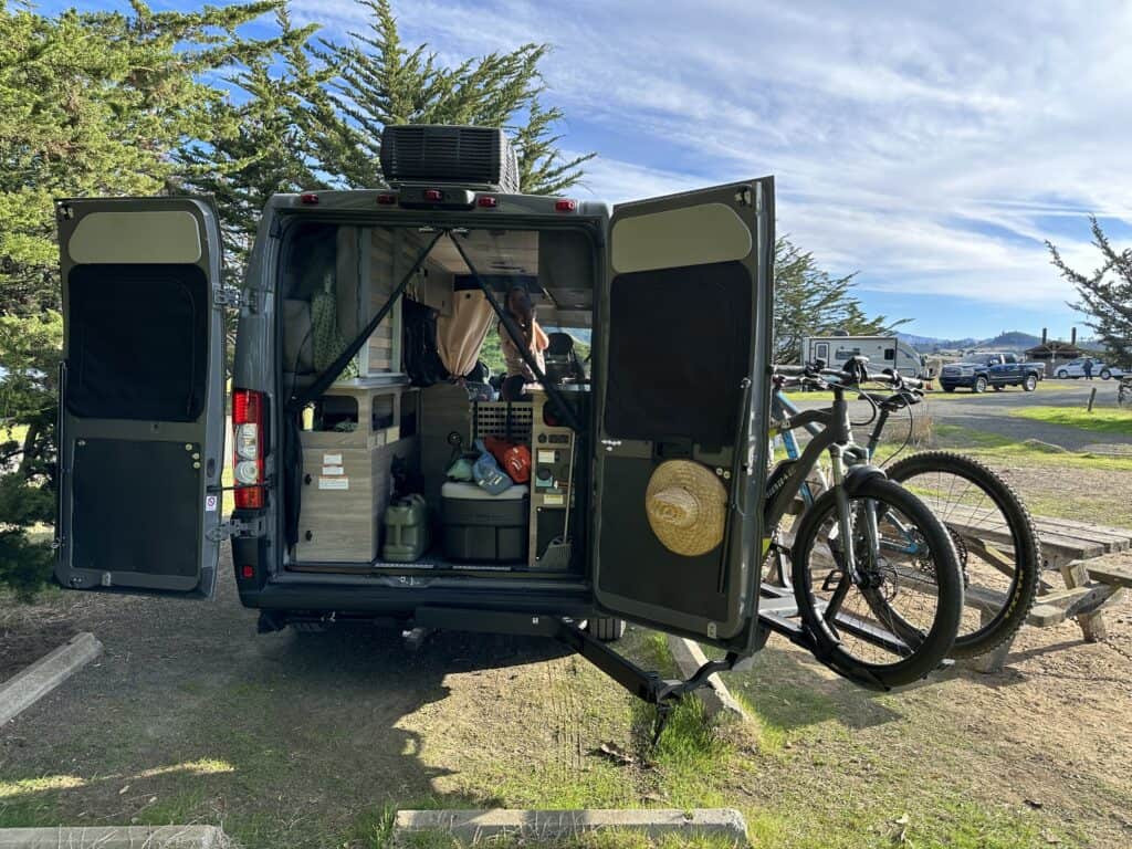 kuat swing away bike rack swung to the side of a van with the rear doors open