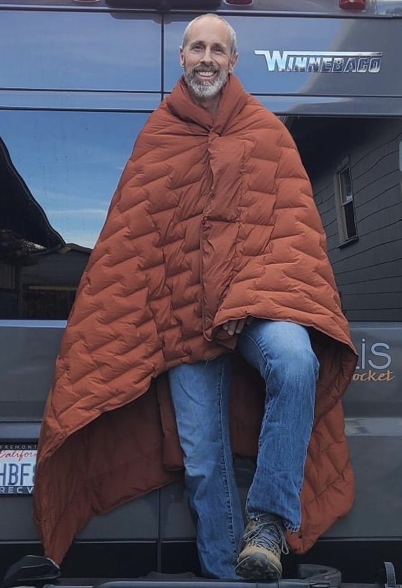 man wearing a down quilt as a poncho