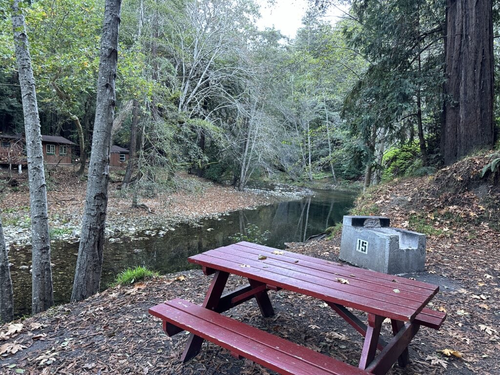 red picnic table with a river in the background