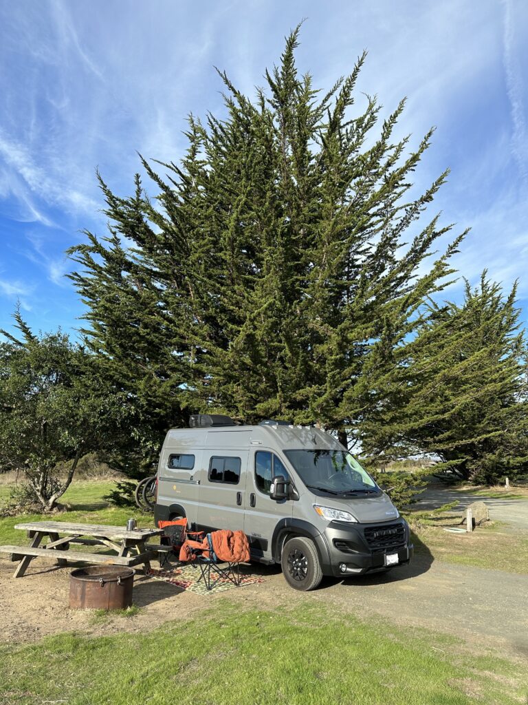 gray class b promaster van parked in a campsite