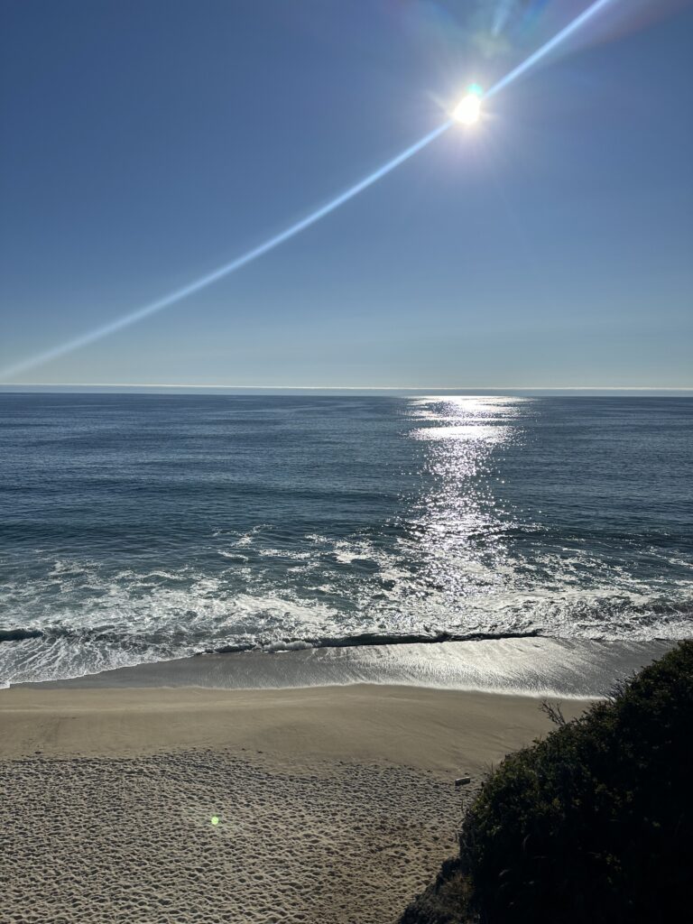 start of the sunset at half moon bay's poplar beach as view from a cliff