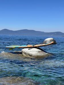 a paddle board balancing on a rock in the lake