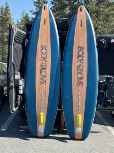 two paddle boards leaning up against the back of the van