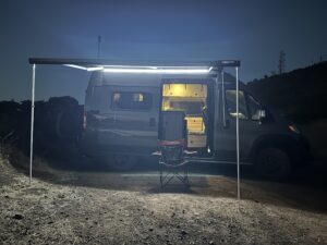 side view of my van at night with the canopy out and lights on